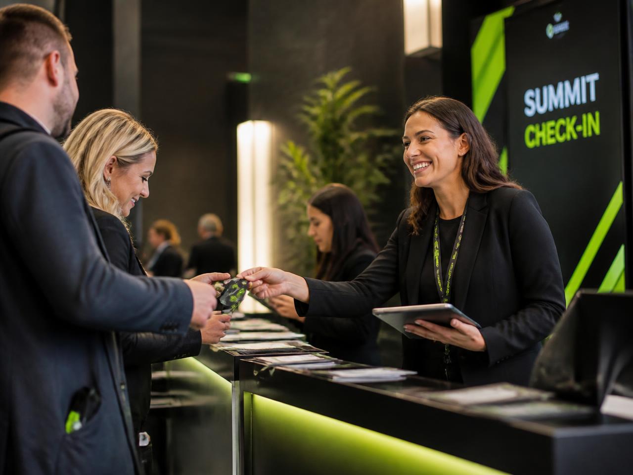 An event coordinator handing a badge to an attendee at a modern check-in desk